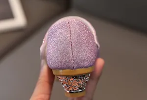 Macro view of pink sequin girl's princess shoe featuring a crystal-encrusted silver heel