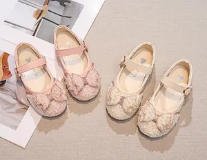 Detail of pink and beige Mary Jane shoes with pearl and rhinestone bow embellishments