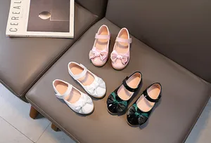 Detailed macro view of pink, white, and black patent leather girl's Mary Jane shoes