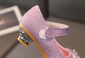 Detailed close-up of girls' glitter Mary Jane shoes with rhinestone block heels