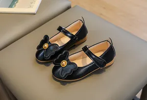 Detail of girls' black Mary Jane shoes with 3D bow and gold bead decoration