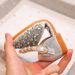 Gros plan montrant la semelle en caoutchouc flexible de cette chaussure argentée à paillettes