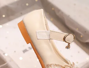 Detailed view of girls' princess shoes featuring pearls, rhinestones, and bow decorations