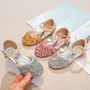 Détail de chaussures de princesse scintillantes pour filles en doré, rose et argenté
