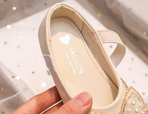 Close-up of beige princess shoes with sparkling rhinestones, pearls and fashion insoles