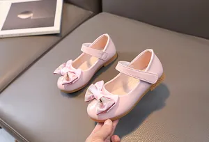 Close-up of pink patent leather girls princess shoes with glitter bow and velcro strap