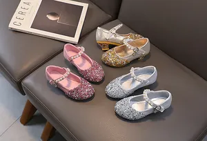 Detailed row of glittering girls' princess shoes with pearls and metallic charms