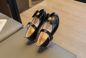 Detail of girls' black Mary Janes with textured leather and large bow on soft rubber sole