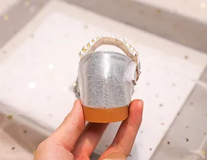 Détail de chaussures Mary Jane argentées pour filles avec bride en perles et semelle gomme