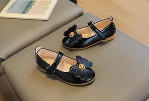 Detail of black Mary Jane shoes for girls with large bow and gold bead accent