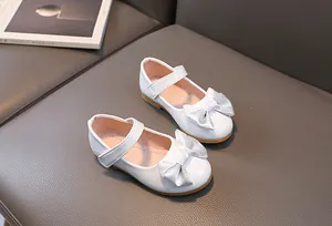 Detail of white Mary Jane shoes with sparkling silver bow and easy hook-and-loop strap