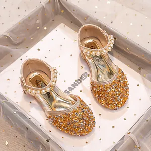 Détail des chaussures Mary Jane dorées à paillettes pour filles avec bride perlée élégante
