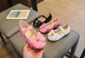 Detail of toddler Mary Jane shoes with double bow and gold bead on velcro strap