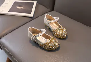 Detailed view of girls sequin Mary Jane shoes with pearl ankle straps and gold glitter