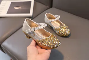 Detail of girl's champagne glitter princess shoes with pearl strap and crystal buckle