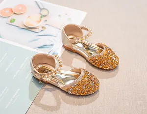 Détail de chaussures Mary Jane à paillettes dorées avec bride perlée pour fillettes