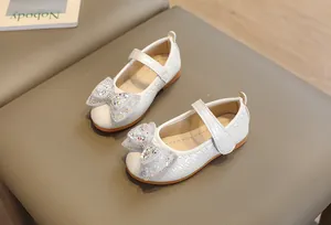 Dettaglio scarpe Mary Jane bianche da bambina con trama intrecciata e fiocco scintillante