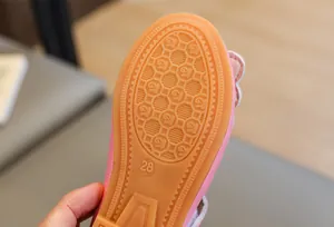 Close-up of pink girls princess shoe with non-slip rubber sole and bear pattern