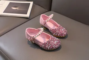 Detailed macro view of pink glitter girls' princess shoes with pearls and gold buckle