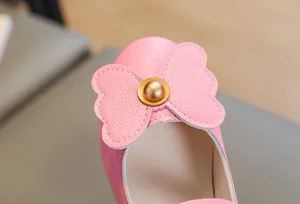 Close-up of pink girls' princess shoes with bow detail and gold bead decoration