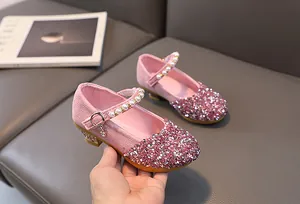 Detail of pink sequin princess shoes with pearl straps and heart pendants