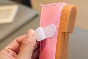 Detail of pink girls flat shoes showing velcro strap closure and leather texture