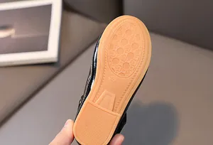 Close-up of durable rubber sole with anti-slip texture on black children's dress shoe