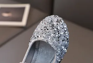 Close-up of sparkling silver sequins and premium stitching on girl's princess dress shoes