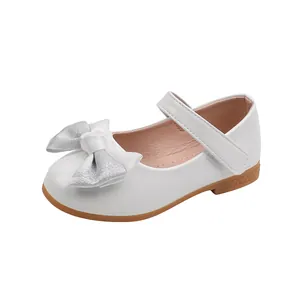 Detail of white patent leather girls Mary Jane shoe with silver glitter bow and strap