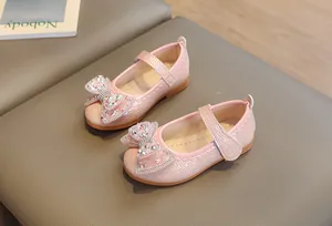 Dettaglio delle Mary Jane rosa con fiocco di strass e trama intrecciata per bambina