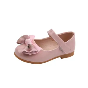 Detail of pink Mary Jane shoes with satin bow and metallic champagne accents