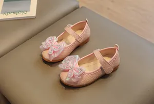 Detail of pink girls Mary Jane shoe with rhinestone bow and woven texture