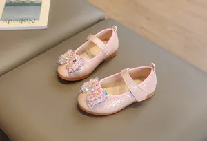 Détail de ballerines roses pour filles avec tissage irisé et nœud décoratif en perles
