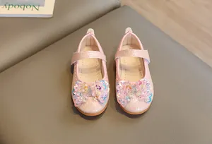 Détail de chaussures princesse roses pour filles avec nœud à paillettes et velcro