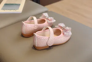 Dettaglio scarpe Mary Jane rosa da bambina con trama intrecciata e fiocco di paillettes