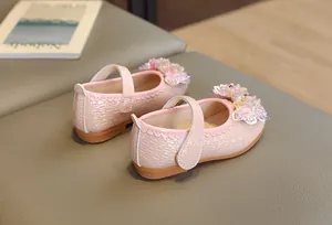 Détail de chaussures Mary Jane rose nacré avec fleur à paillettes et bords ondulés