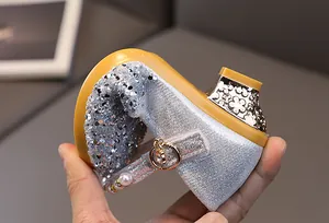 Detail of silver sequin girl shoes showing the flexible soft sole and floral hollow heel