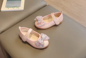 Dettaglio di scarpe Mary Jane rosa da bambina con fiocco di strass e trama a rilievo