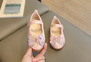 Détail de chaussures Mary Jane roses avec nœud à paillettes et fermeture velcro fille