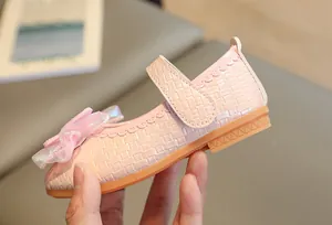 Detailed side view of pink Mary Jane shoes with organza bow and wavy trim for girls