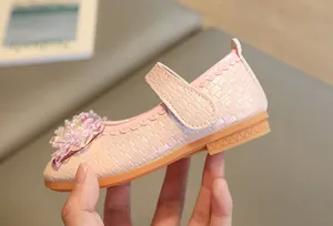 Gros plan de chaussures Mary Jane roses avec texture tissée et détails de fleurs perlées