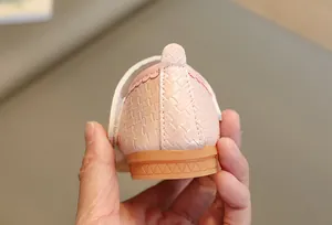 Détail de chaussure rose tissée pour fille avec semelle en gomme durable et bride velcro