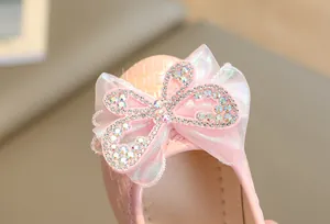 Detail of pink girls princess shoe featuring sparkling rhinestone bow and woven texture