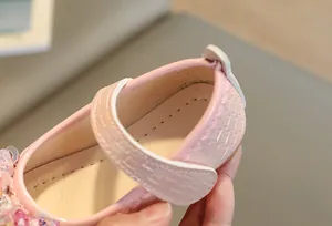 Détail de chaussures Mary Jane roses avec paillettes et bords festonnés pour filles