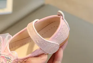 Detailed view of pink girls' Mary Jane shoe with pearl rhinestones and lace trim
