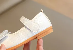 Close-up of pearl white girls Mary Jane shoes with woven texture and durable rubber sole