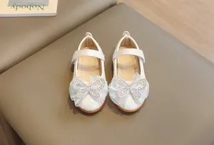 Detail of off-white girls' princess shoes with rhinestone mesh bow and embossed leather