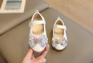 Détail de ballerines blanches pour filles avec nœud en perles colorées et semelle en gomme