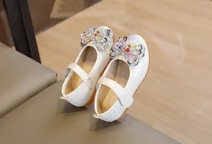 Détail de chaussures Mary Jane blanches pour filles avec nœud perlé et cuir texturé