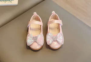 Macro detail of pink crocodile pattern leather girl shoes with rhinestone heart bow